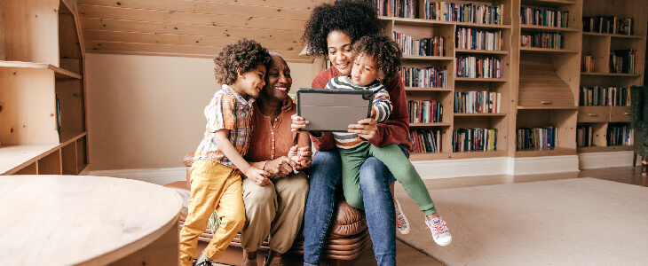 two women and two children cuddling up with a tablet special needs planning